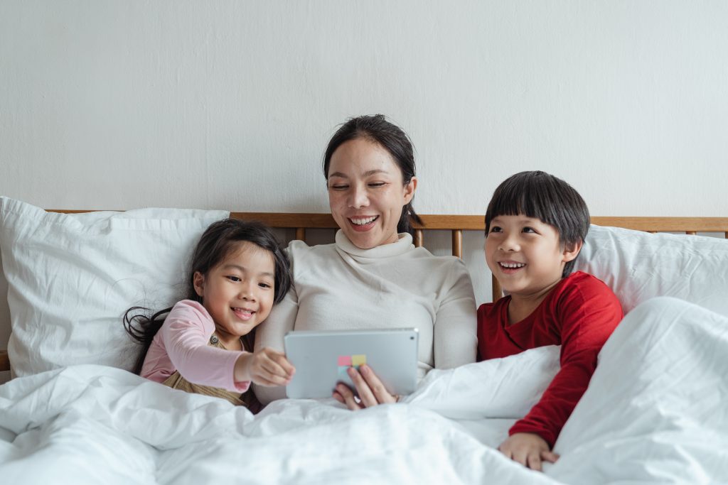 Kids and Mom on Tablet in Bed
