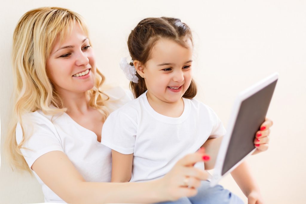 A mom and daughter look at a tablet that is protected by one of the best kid's tablet cases.