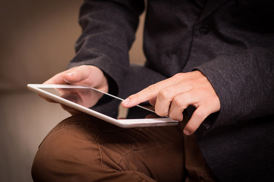 Man wearing business suit browsing using tablet